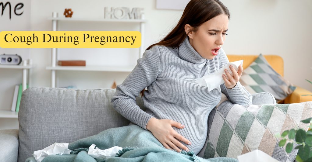 Pregnant woman sitting on a couch with pillows and a bed nearby, experiencing a cough in a relaxed indoor setting.