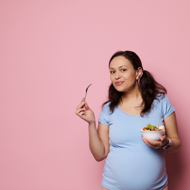 Pregnant woman eating kiwi for pregnancy nutrition